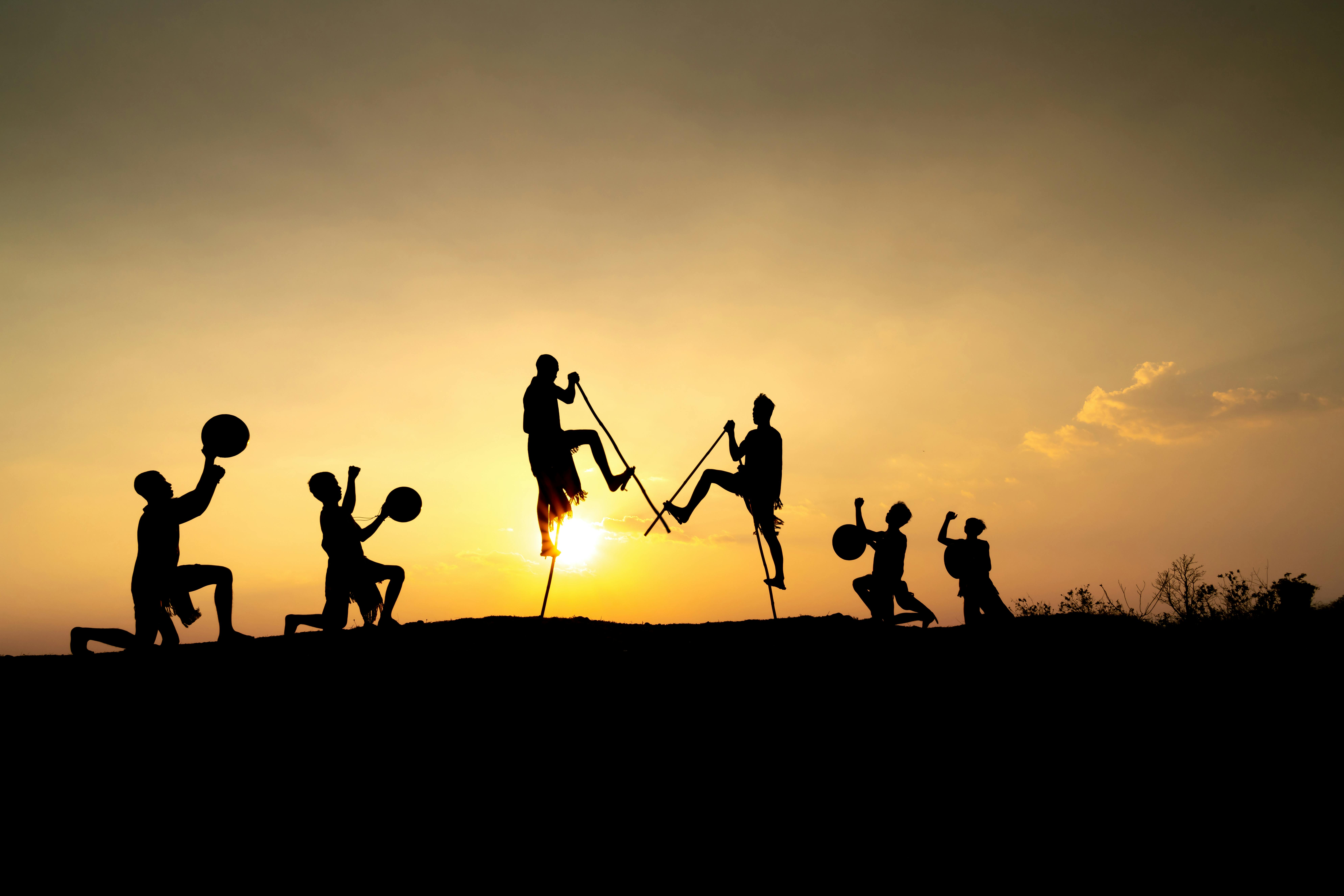People helping each other at sunrise - UOMU taking action for a fairer world